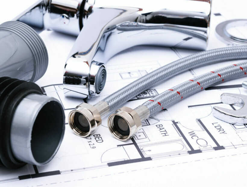 Plumbing equipment on a house plan Plumbing tools and faucet on a blueprint project in close-up