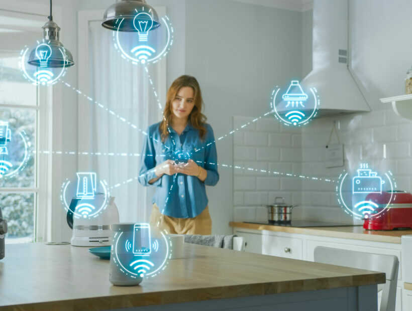Internet of Things Concept: Young Woman Using Smartphone in Kitchen. She controls her Kitchen Appliances with IOT. Graphics Showing Digitalization Visualization of Connected Home Electronics Devices Internet of Things Concept: Young Woman Using Smartphone in Kitchen. She controls her Kitchen Appliances with IOT. Graphics Showing Digitalization Visualization of Connected Home Electronics Devices